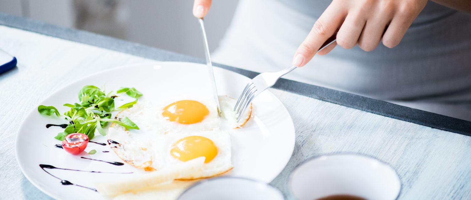 mujer comiendo huevos fritos fuente de proteína
